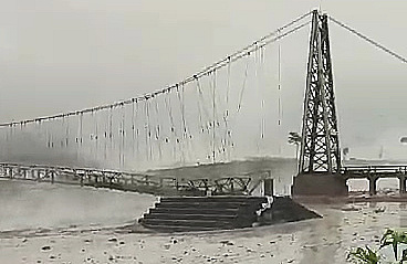 Jembatan gantung Kali Regoyo yang terlihat putus akibat terjangan derasnya lahar dingin Gunung Semeru, Jumat (7/7/2023). (Foto: tangkapan layar)